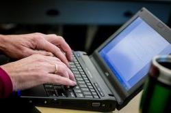 Hands typing on a laptop