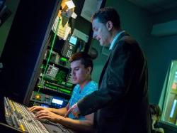 Photo of David sanders with student in broadcast production booth.