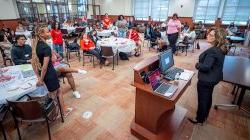 teacher stands in front of conference room full of students